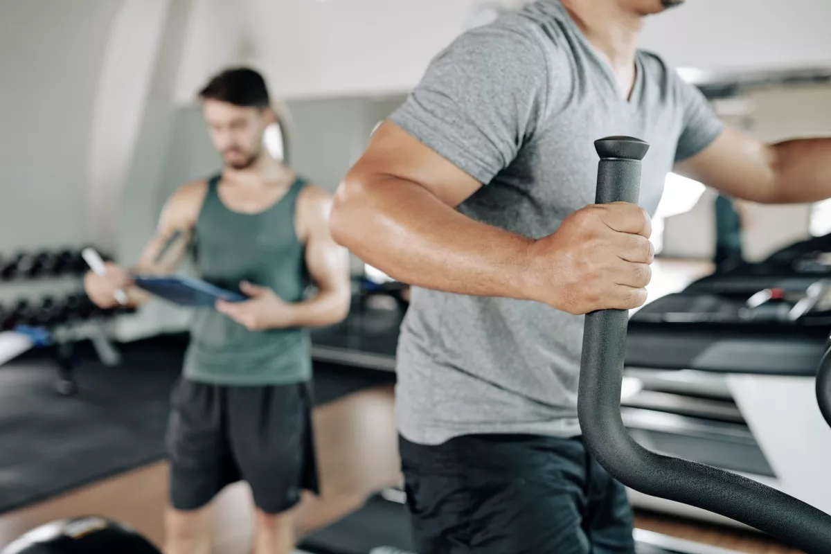 Férfi intenzív HIIT-edzést végez elliptikus tréneren