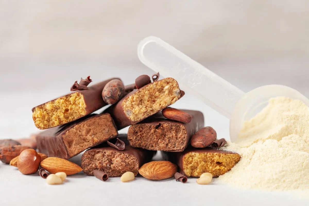 Csokoládés proteinszeletek, mandula és proteinpor adagolókanállal